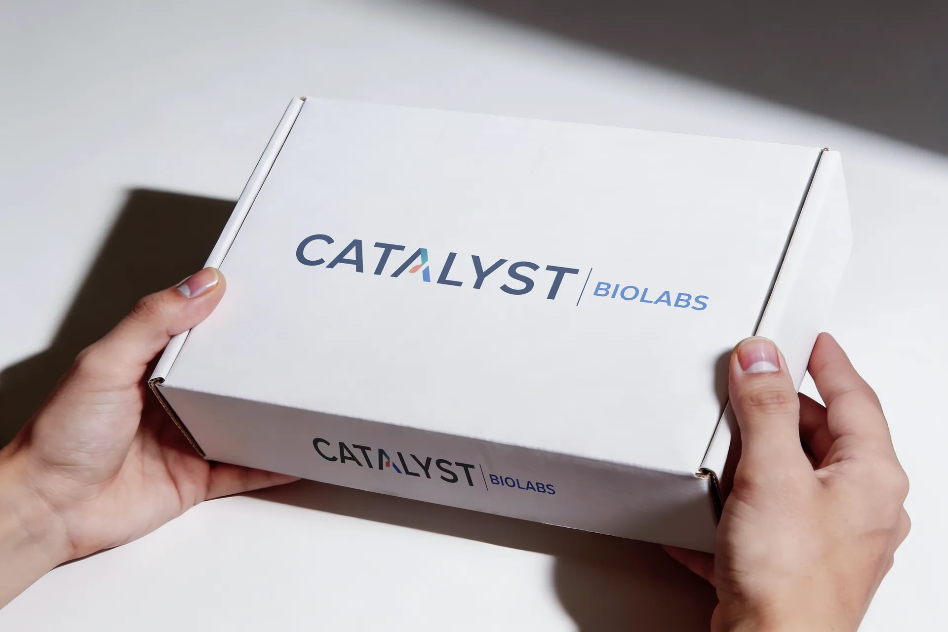 A Catalyst Biolabs shipper held in two hands